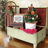 Open vintage wooden travel trunk repurposed as storage with holiday decorations inside