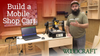 Woodworker demonstrating a mobile shop cart with mounted CNC router and laptop in workshop.