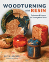 Woodturned bowls and containers combining natural wood burl and colorful resin accents on a workshop surface