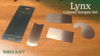 Four metal cabinet scraper blades of different shapes displayed on a wooden surface next to their packaging labeled Lynx