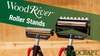 Two WoodRiver roller stands with adjustable height and metal rollers for supporting wood pieces in a workshop setting