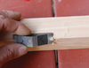 Hand holding WoodRiver corner easing plane smoothing edge of wooden board with shavings