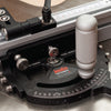 Close-up of a miter gauge with adjustable angle scale and ergonomic handle on a table saw.