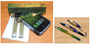 Woodturning tools, a block of wood, a smartphone, and four turned pens on a wooden surface