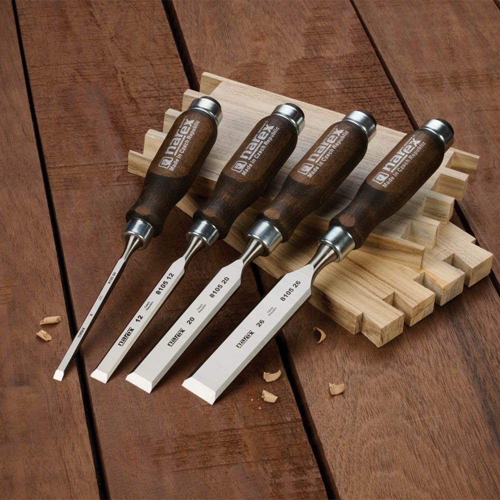 Set of wooden chisels with metal blades on a wooden surface
